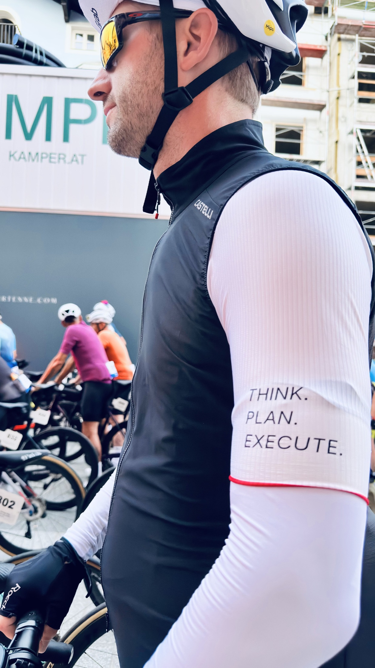 Nahaufnahme von Christian im Radtrikot; auf seinem weißen Ärmel steht Think. Plan. Execute.