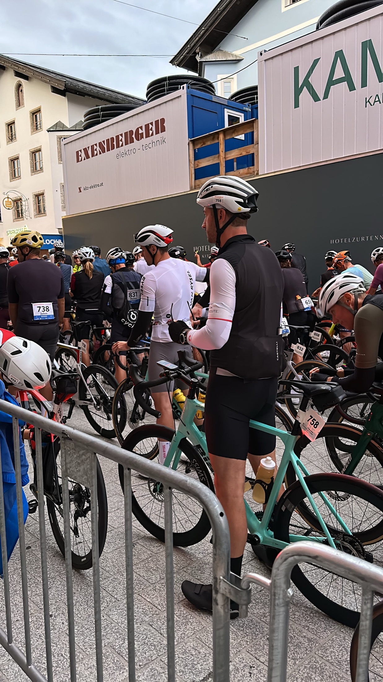 Christian steht von hinten mit seinem Rennrad inmitten zahlreicher Fahrer im Startbereich.