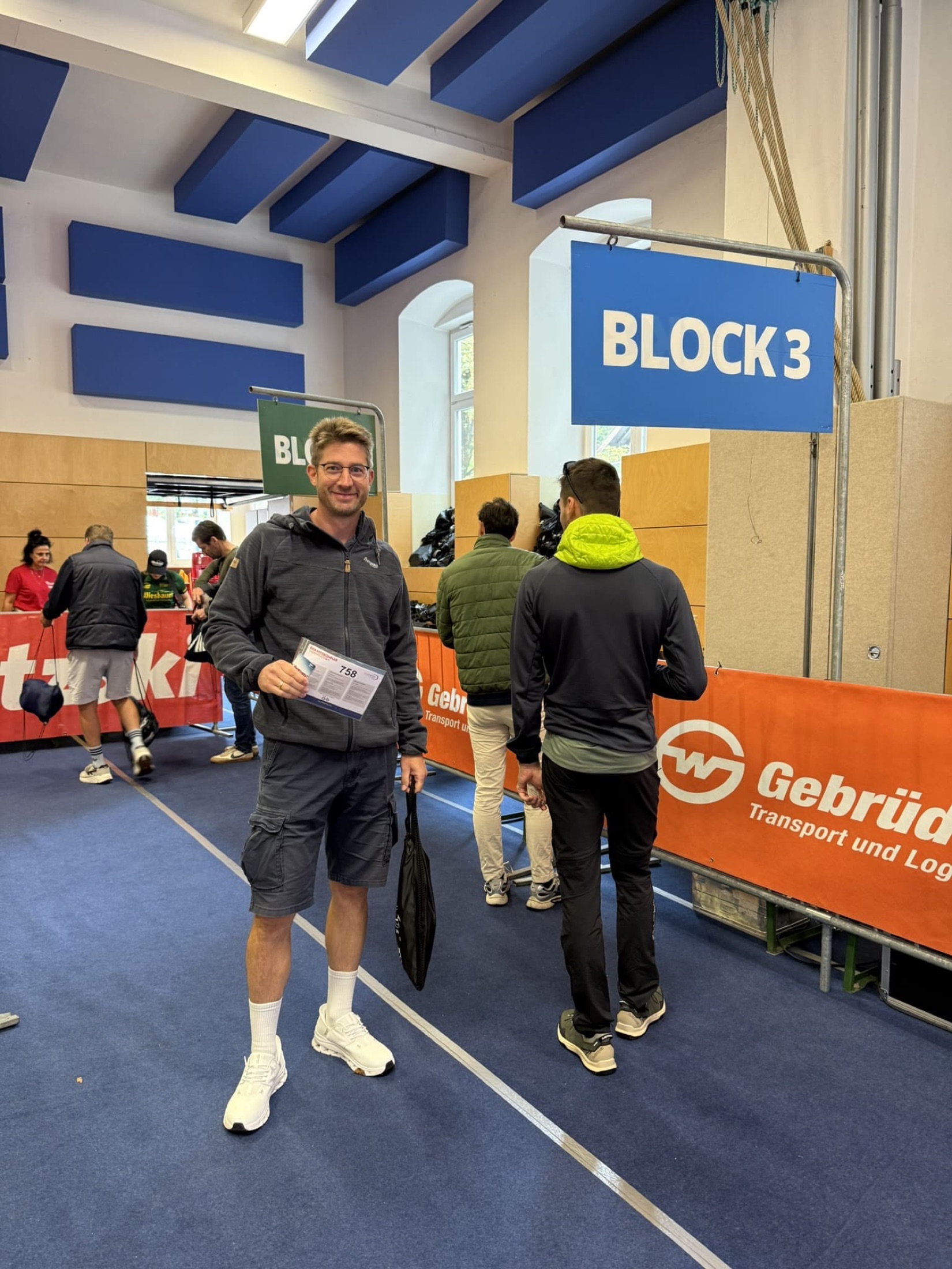 Christian hält die Startunterlagen mit der Nummer 758 unter einem Schild mit der Aufschrift Block 3.